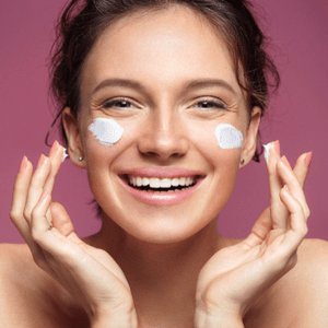 une fille se barbouille de crème sur le visage