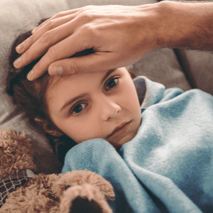 petite fille malade sur le canapé sous une couverture