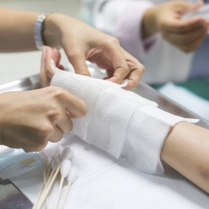 le médecin applique des pansements sur le bras du patient