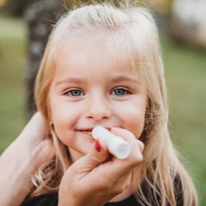 la mère applique un baume à lèvres sur sa fille