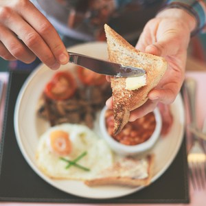 mains de la jeune femme pendant qu'elle prend son petit déjeuner