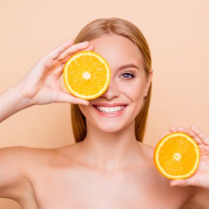 Jolie fille pure naturelle ayant deux morceaux d'orange