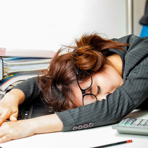 vrouw slaapt met hoofd op bureau
