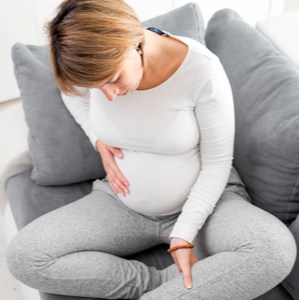 une femme enceinte masse son veau
