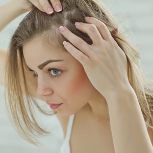 fille nerveuse regardant dans le miroir son cuir chevelu