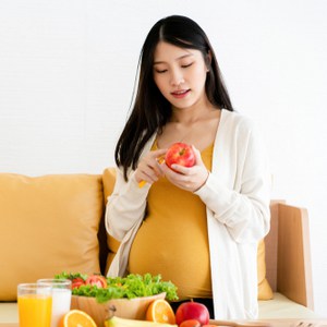 Femme enceinte à une table avec des fruits