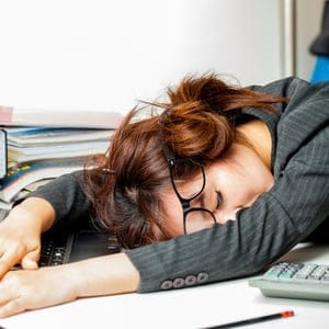 femme dormant avec la tête sur le bureau