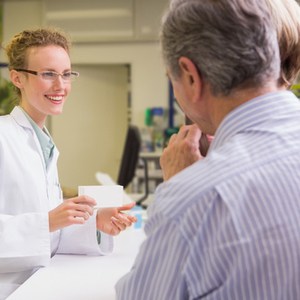 vrouwelijke apotheker praat met ouder echtpaar