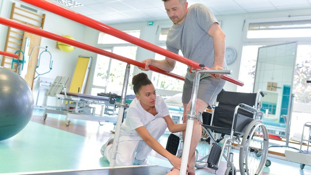 Ergotherapeut helpt de patiënt om te lopen